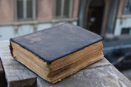 Vintage old book on stone, grunge textured cover. Retro styled image with blurred background