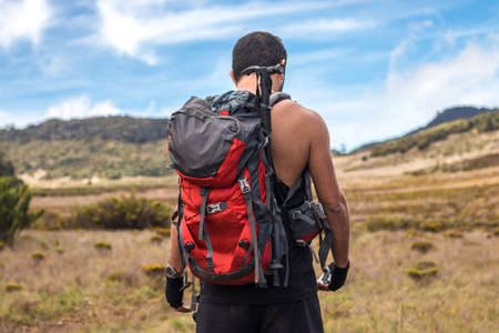 hiker man in black sportswear with crossed arms and confident gaze in the warm savanna of Chirripo...