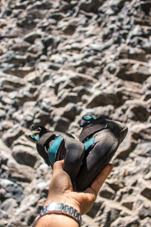 woman suspended with climbing ropes in the air on a natural stone wall with harness and helmet on a sunny dayの写真素材