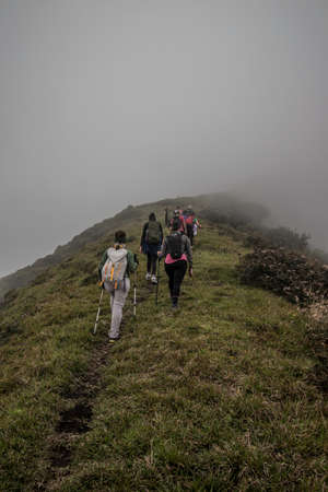 vertical shot of a hiker carrying his backpack while walking along a trail in the green mountains of Costa Ricaの写真素材