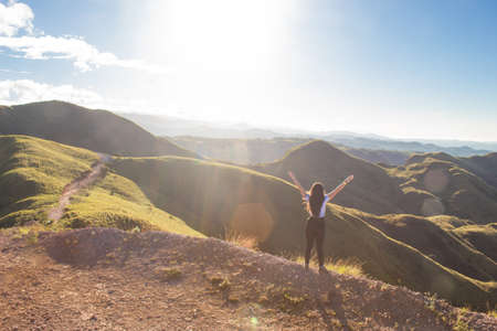 group of hikers walking to the wooden cabin into a green mountainsの写真素材