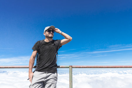 tourist posing with glasses and cap at a viewpoint with view of a volcano crater in Irazu Volcano...
