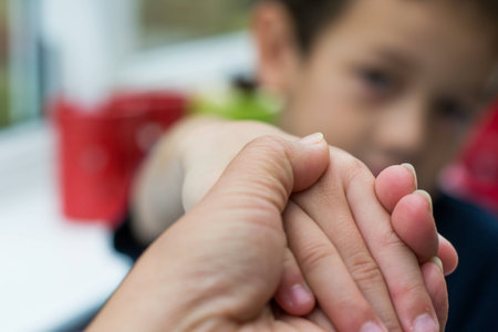 Blurry face of kid let mom to hold his handsの写真素材