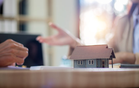 Real estate agent giving house model to customer after signing agreement contract.の写真素材