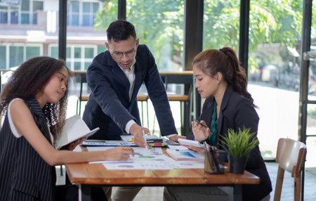 Business people discussing the charts and graphs showing the results of their successful teamworkの写真素材