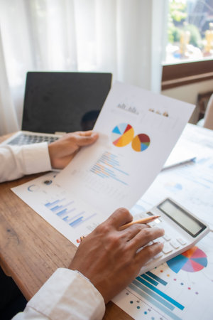 Businessman analyzing investment charts with calculator and laptop. Accounting concept.の写真素材