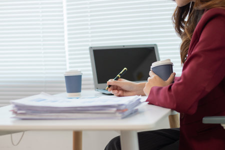 Businesswoman reviewing high-risk market analysis and investment documents for efficiencyの写真素材