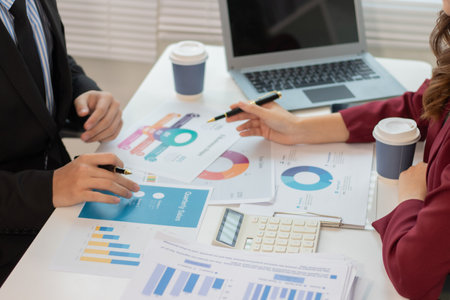 Businessman and woman discussing and using market analysis chart to reduce investment risk.の写真素材