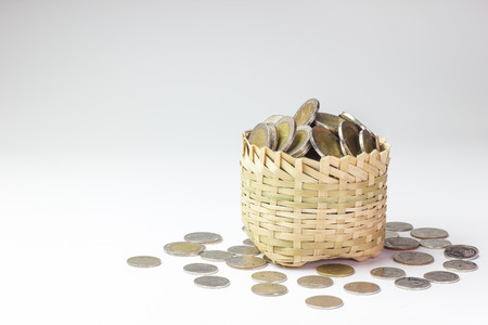 Many coin in a bamboo basket on white background. Concept financial or business. Keep saving money for good thing in the future.の写真素材