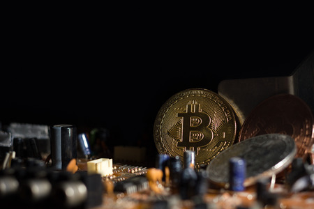 Bitcoin placed on the circuit of electronic mainboard. Concept of bitcoin mining business.の写真素材