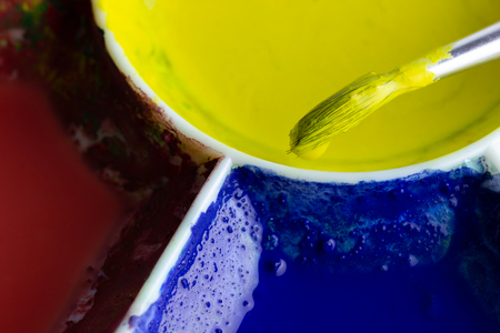 The brush is dipped in yellow color and the palette on a white background. Suitable for background, articles about artistic.の写真素材