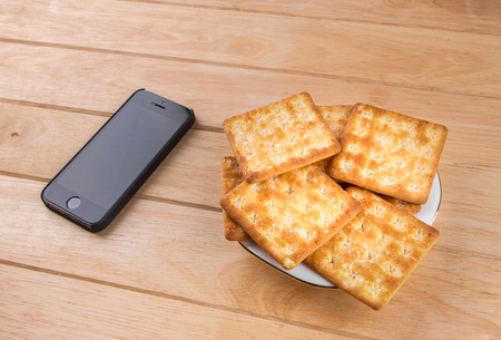 The bread and phone put on the tableの写真素材