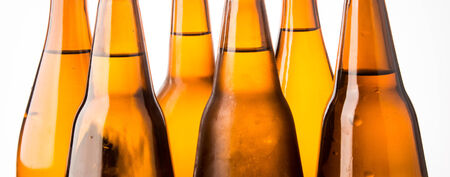 Cold beer bottle stacked on white background の写真素材
