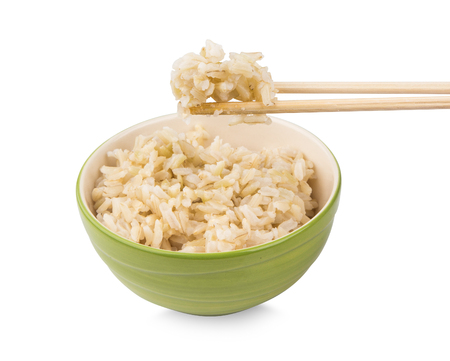 Brown rice with chopsticks in a cup on white backgroundの写真素材