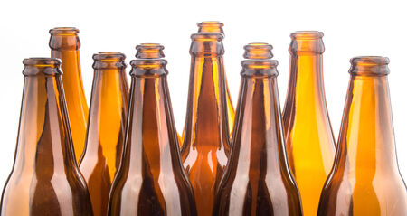 Brown beer bottles stacked isolated on white background の写真素材