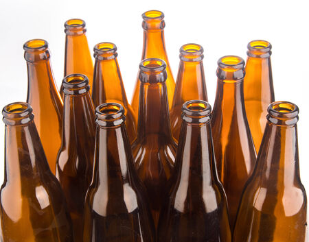 Brown beer bottles stacked isolated on white background の写真素材