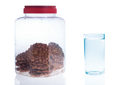 Plastic candy box with a glass of water isolated on white の写真素材