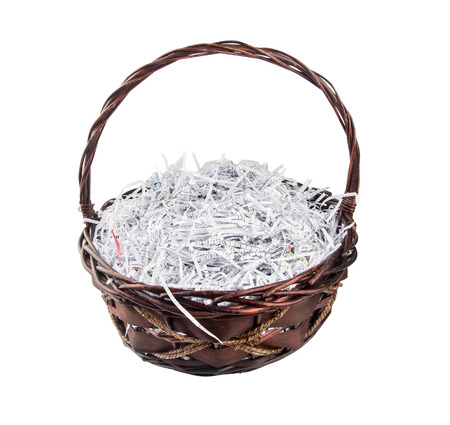 Empty fruit baskets and paper strips from a shredder isolated on whiteの写真素材