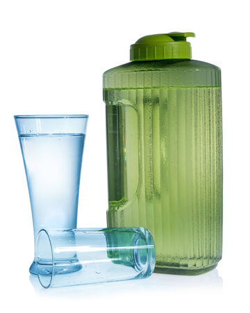 Green bottle with glass of water on white background の写真素材
