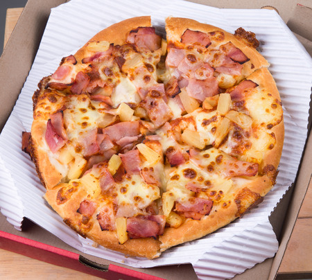Tasty pizza in box on whiteの写真素材