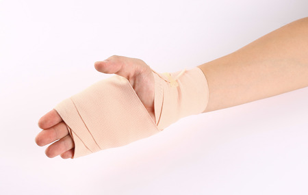 Hand bandaging injuries on white.の写真素材