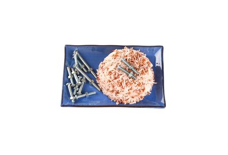 Brown rice with screw in plate on a white background.Concept eat screw instead of food.の写真素材