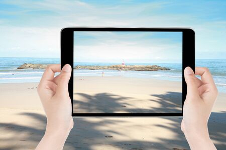 Touch screen tablet in hand a photography the sea view on beach