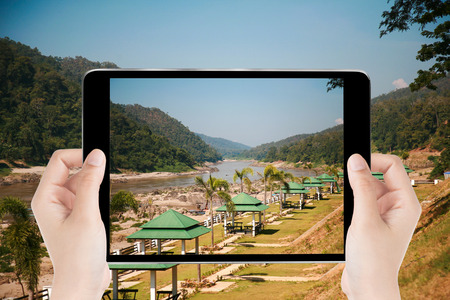 Touch screen tablet in hand a photography the river central mountains - Travel concept.の写真素材