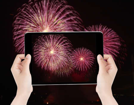 Touch screen tablet in hand a photography the fireworks - Celebrate.の写真素材