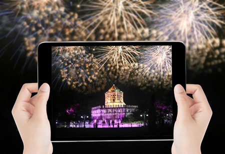 Touch screen tablet in hand a photography the firework over the thai temple - Travel concept, Public...
