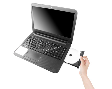 Hand of a young woman inserting a cd in laptop isolated on a white.の写真素材