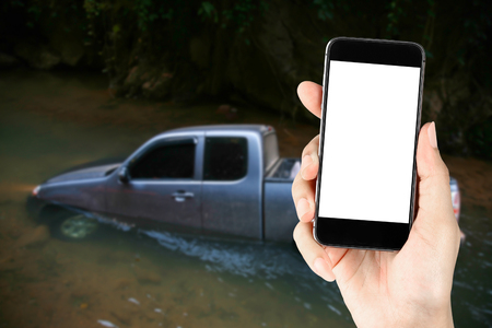 Touch screen in hand on flooded car.の写真素材