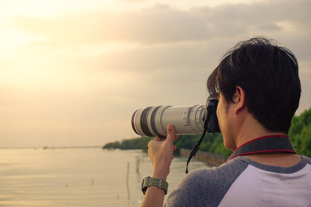 Man take a photo relax at river with evening light.の写真素材