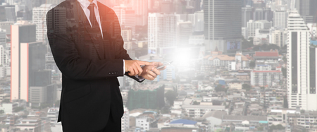 Touch screen in hand businessman on city night light. Connection concept.の写真素材