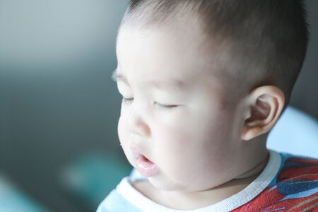 An Asian baby is wondering in the morning sunshine - Focus piont and Light fair concept.の写真素材