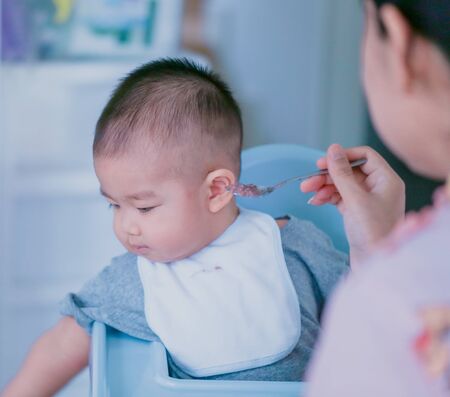 The baby does not want to eat the food that the mother feeds - Bright tone and focus point concept.の写真素材