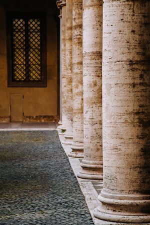 Old street with arches and columns in Rome, Italy