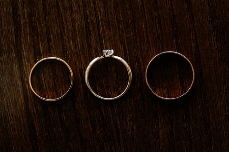Wedding rings arranged on the brown wooden table. Wedding card, Valentine's Day greeting.