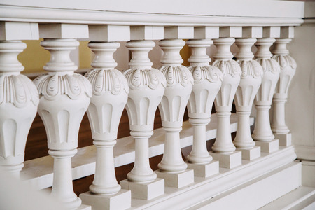 A row of white concrete balusters. Baroque style.