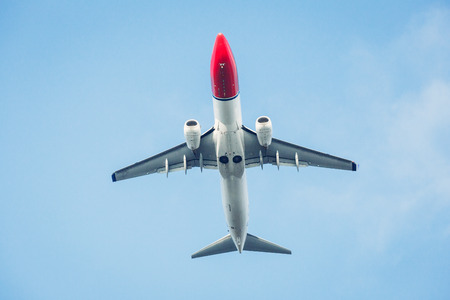 Passenger airplane isolated against the blue sky. Front view.