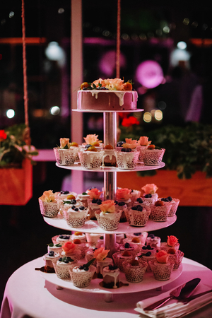 Purple and pink cupcake stand. Decorated with berries and leaves.の写真素材