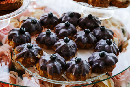 Cupcakes decorated with blackberries served on a banquet table.