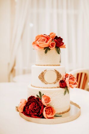 White wedding cake decorated with red roses.の写真素材