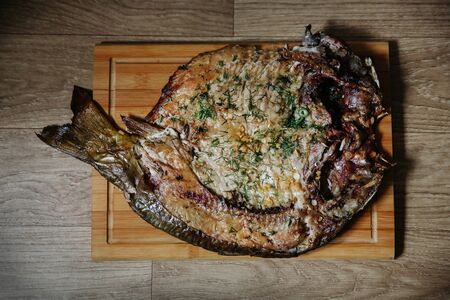 Smoked carp fish served on a table. Top down view.