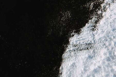White snow on black ice background. Top down view.