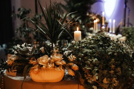 Table decoration with burning candles, white flowers.