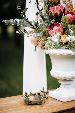 Table with wedding rings at wedding ceremony outdoors in the garden.の写真素材