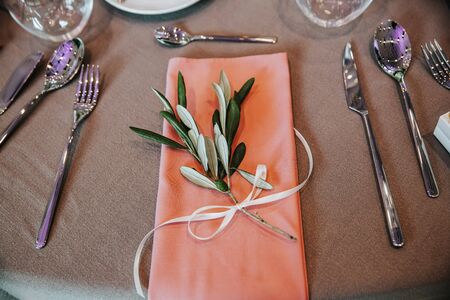 Close up of beautiful decorated table with a branch of olive tree. Top down view.の写真素材