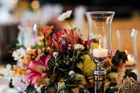 Beautiful, decorated table with flower decorations and burning candle.  Wedding or party decorations.の写真素材