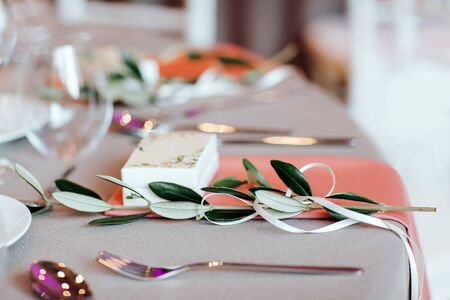 Close up of beautiful decorated table with a branch of olive tree.の写真素材